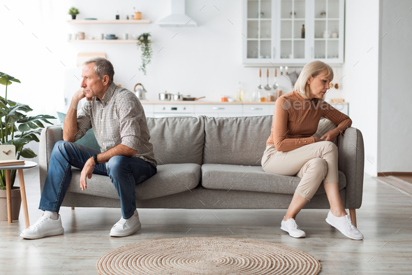 Offended Mature Spouses Sitting Back-To-Back Not Speaking After Quarrel Indoor