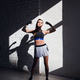 Female kickboxer standing in a boxing studio while dust particles flies in sunflare light background - PhotoDune Item for Sale