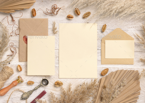 Wedding suite cards and envelopes near dried plants, palm leaves and pampas grass
