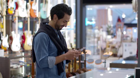 Young handsome man using smartphone and payment by smartphone contactless