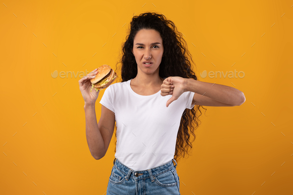 Angry Latin Lady Holding Burger Showing Thumbs Down