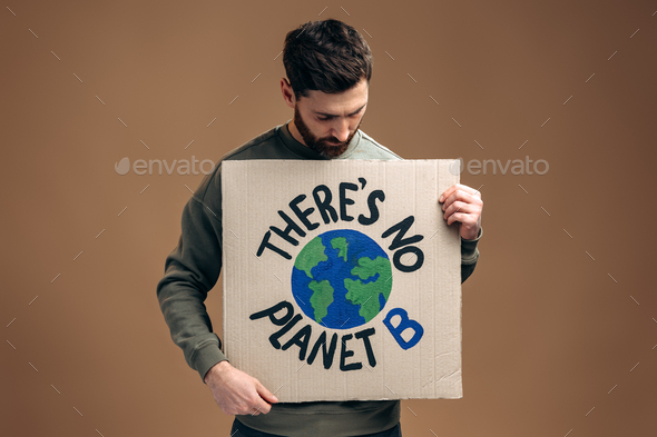 There is no planet B. Caucasian serious man holding carton placard with signs and looking at it