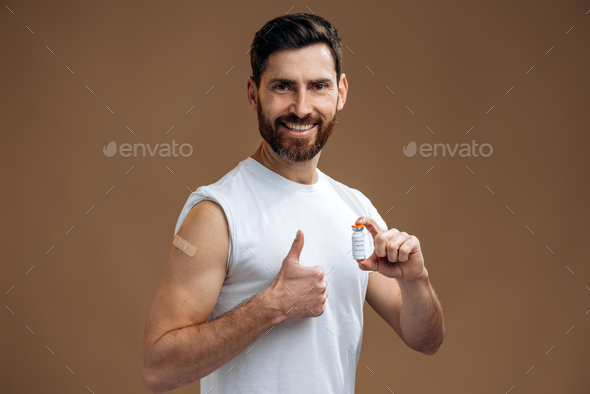 Bearded man showing plastered arm after getting coronavirus vaccine