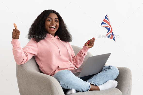 Happy black woman student with laptop and flag of UK