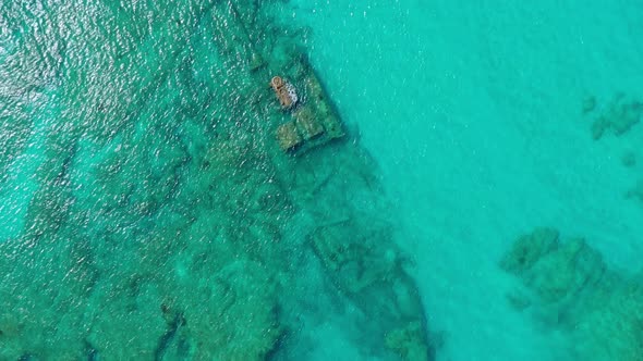 Birdseye Aerial Descend of Sunken Cargo Ship Barco Hundido at Bottom in Beautiful Clear Waters of Sa alt