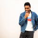 relaxed young black man in denim jacket against white wall - PhotoDune Item for Sale