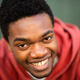Close up happy young black man against green wall - PhotoDune Item for Sale