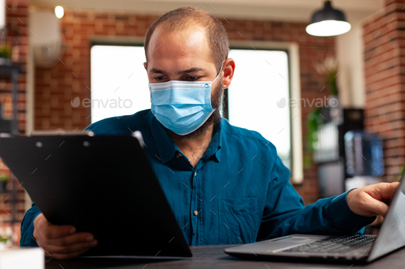 Bookkeeper wearing medical protection face mask to prevent infection with covid19