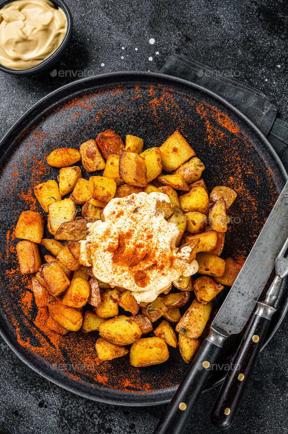 Patatas Bravas, traditional Spanish tapas, baked potato with spicy