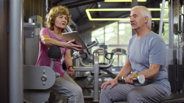 Pair of Seniors Exercising in Gym alt