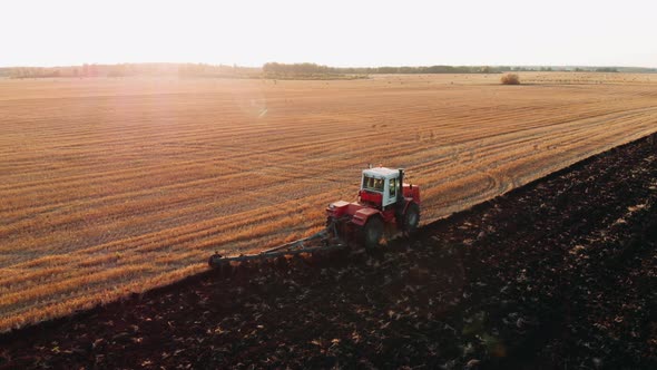 Aerial View of a Agricultural Tractor with a Plow During Field Work on One Agricultural Field in alt