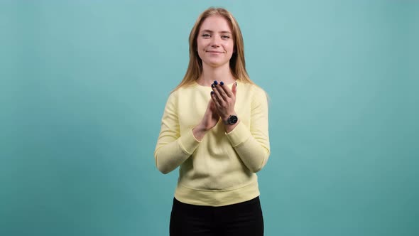 Applauding Young Pretty Girl, Clapping Over Turquoise Background. alt
