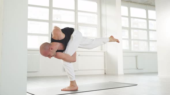 Calm Caucasian Yogi Male with Bald Head Keep Balance While Performing Posture on One Leg
