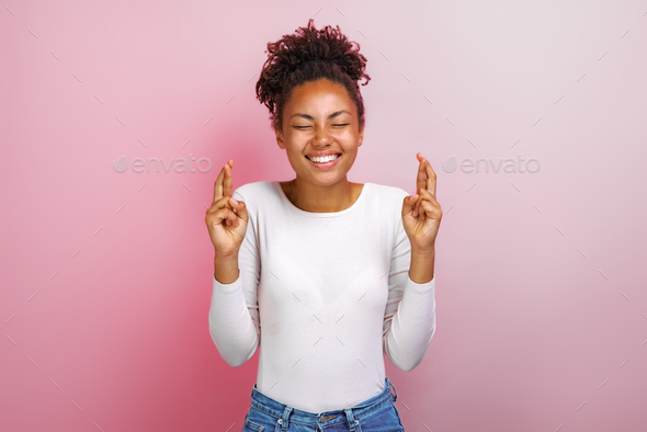 Cute woman crossing her fingers and wishing for good luck - Image