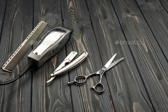Men\'s haircut tools on a wooden, dark background.