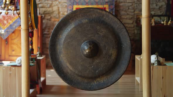 Person Hand Striking Small Asian Gong alt