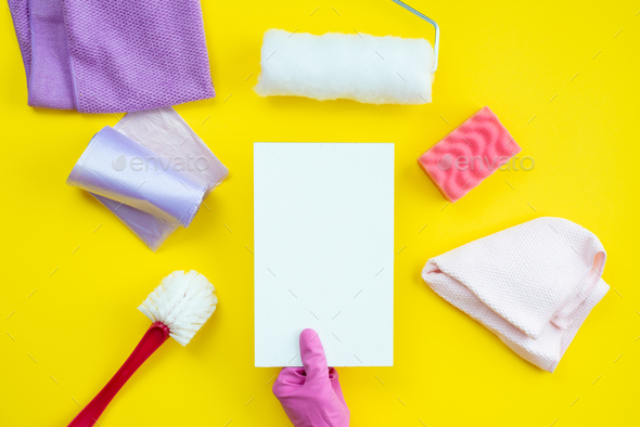 Cleaning items and a clean layout lie on a yellow background. Cleaning service concept.