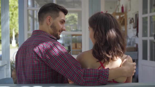 Back View of Young Woman and Man Sitting at the Table at the Old House alt