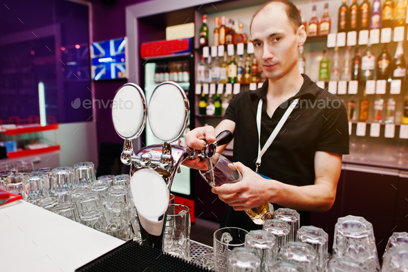 Bartender pours a beer at the bar in the club
