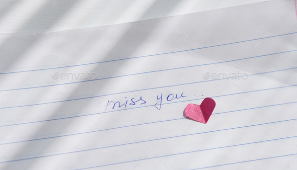 miss you note hand written on a paper.