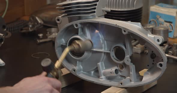Motorcycle Engine Parts Heating Before Assembling in Repair Shop Garage alt