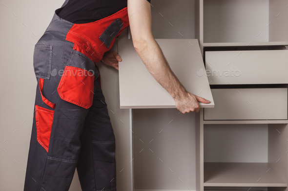Furniture assembler assembles modern sliding door wardrobe