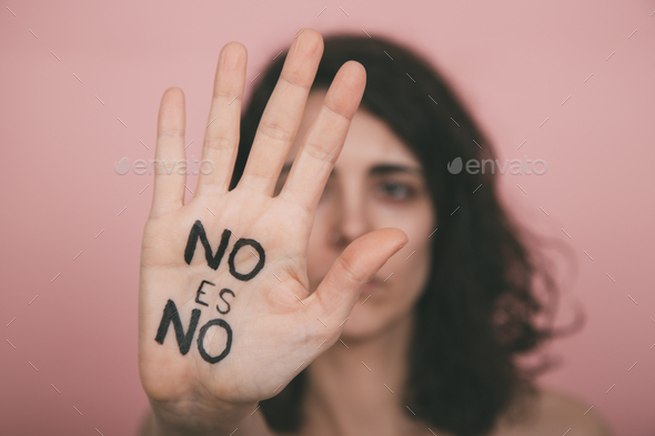 Woman\'s hand with no means no vindictive painted letters with pink background. Feminism