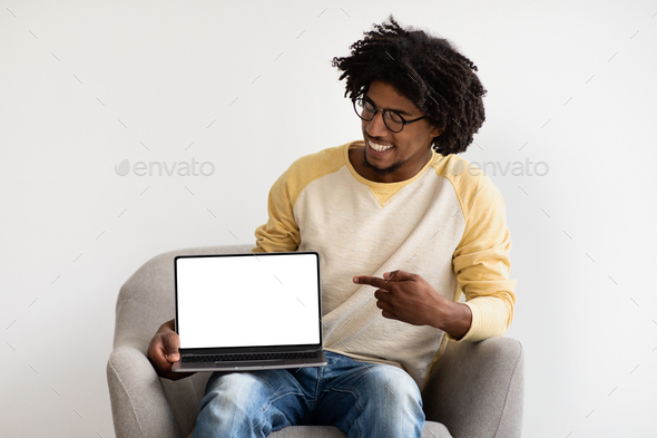 Great Website. Smiling Young Black Man Pointing At Blank Laptop Screen