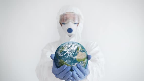 Doctor in Protective Wear Holding the Planet in Hands. Coronavirus Concept