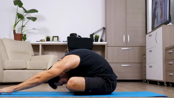 Man Doing Different Yoga Poses on a Blue Mat in His House alt