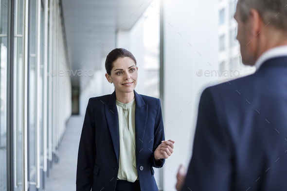 Portrait of smiling businesswoman listening to business partner - Stock Photo - Images