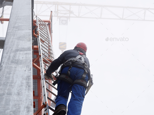 Germany, Bavaria, Garmisch-Partenkirchen, Zugspitze, installer climbing ladder on pole at goods cabl - Stock Photo - Images