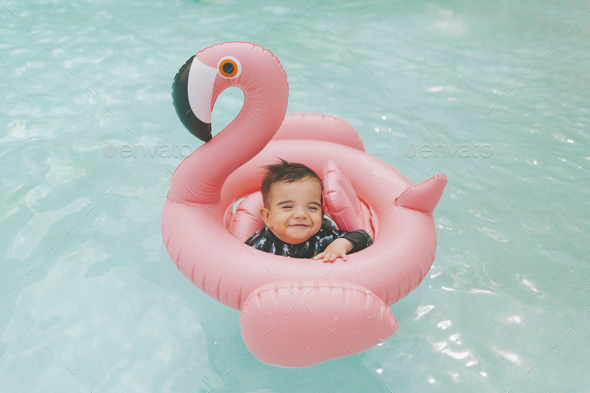 Carefree baby boy in pink flamingo float in swimming pool Stock Photo ...