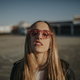Portrait of young woman with defiant attitude wearing sunglasses outdoors - PhotoDune Item for Sale
