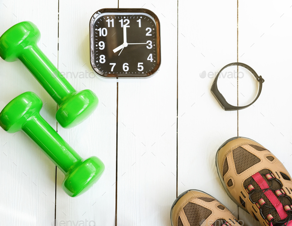 Time for exercising concept. alarm clock and dumbbells