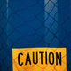 yellow sign with a &quot;caution&quot; warning on a blue shipping container - PhotoDune Item for Sale
