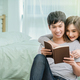 Happy Asian Lover or Couple reading the notebook on the bed in bedroom at home - PhotoDune Item for Sale