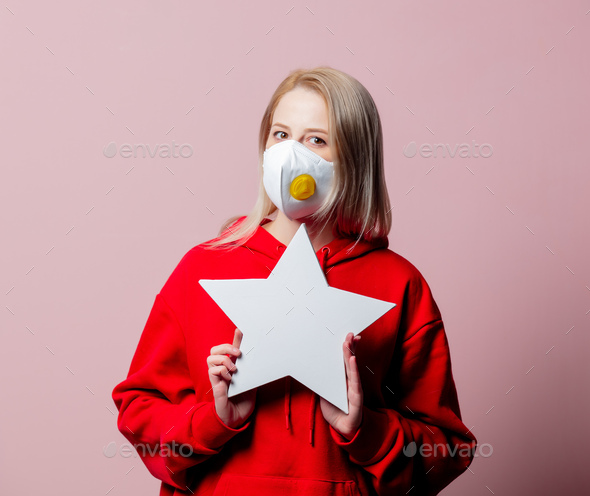Woman in FFP2 anti-dust standart face mask hold star shape banner on pink background