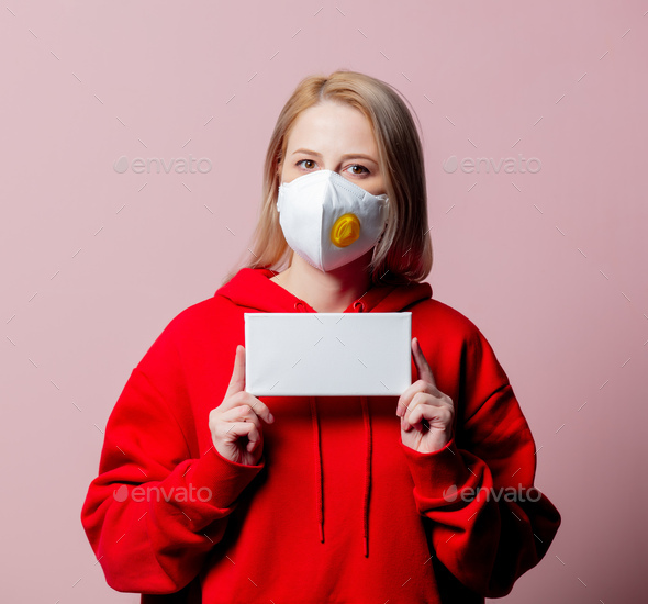 Woman in FFP2 anti-dust standart face mask hold banner on pink background