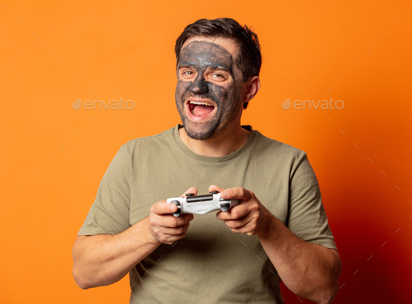 smiling huy with cosmetic mask and game controller