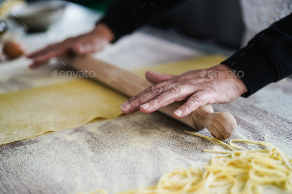 Woman preparing dough for ravioli inside pasta factory