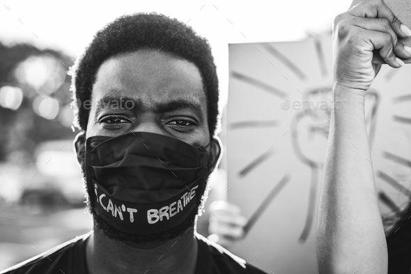 Young black man wearing face mask during equal rights protest - Focus on man eyes