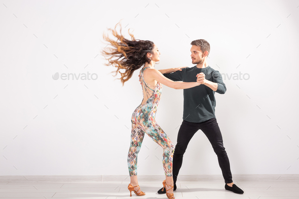 Young couple dancing latin dance bachata, merengue, salsa, kizomba. Two elegance pose over white
