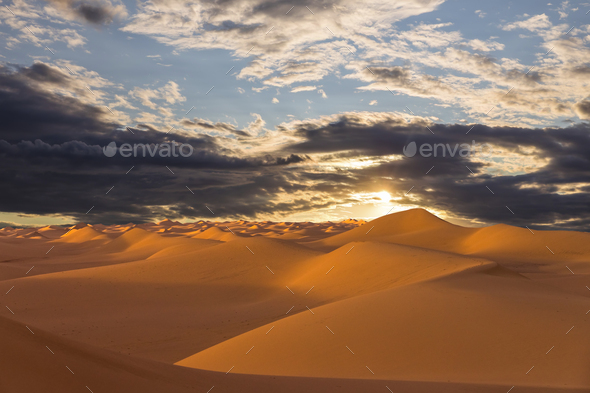 Sunset over the sand dunes in the desert. Arid landscape of the Sahara desert - Stock Photo - Images