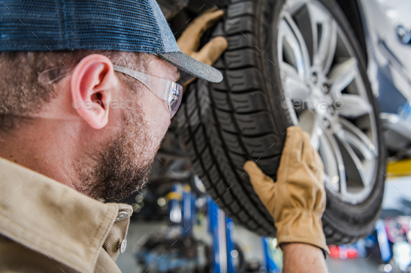 Auto Service Worker Replacing Tires and Balancing Car Wheels - Stock Photo - Images