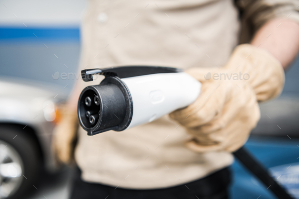 Electric Vehicle Smart Charger Plug in Mens Hand - Stock Photo - Images