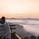 Young couple traveler looking at sea of mist and sunset over the mountain at Mae Hong Son, Thailand - PhotoDune Item for Sale