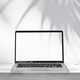 Empty screen laptop on a wooden table with shadow of palm leave on white cement wall background - PhotoDune Item for Sale