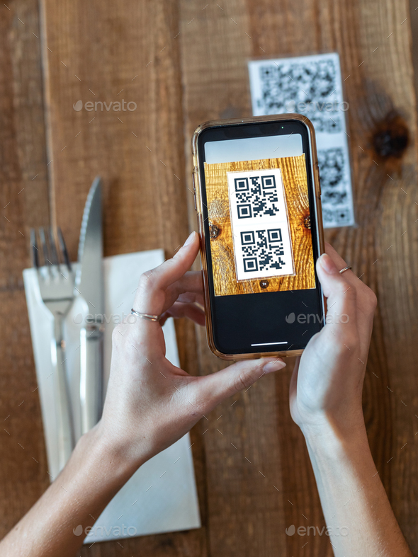 woman hands using the smart phone to scan the qr code to select food menu in the restaurant.