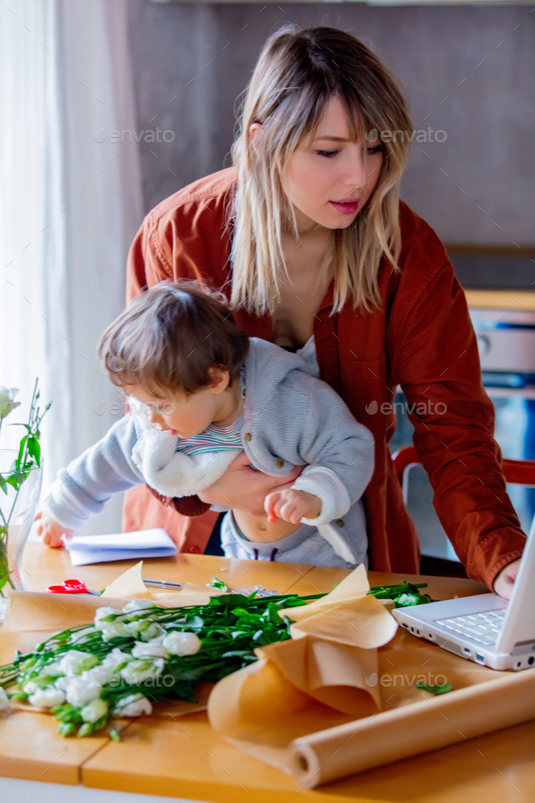 Mother with a child trying to working as a florist businesswoman